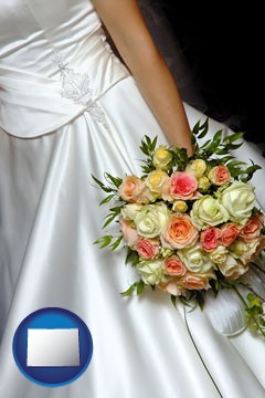 a bride, wearing a white wedding dress and holding a beautiful bridal bouquet - with Colorado icon