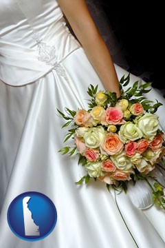 a bride, wearing a white wedding dress and holding a beautiful bridal bouquet - with Delaware icon
