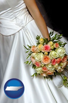 a bride, wearing a white wedding dress and holding a beautiful bridal bouquet - with Tennessee icon