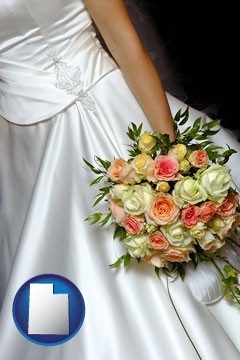 a bride, wearing a white wedding dress and holding a beautiful bridal bouquet - with Utah icon