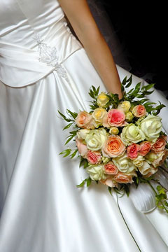 a bride, wearing a white wedding dress and holding a beautiful bridal bouquet