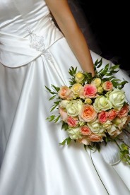 a bride, wearing a white wedding dress and holding a beautiful bridal bouquet
